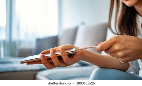 Woman Hands Plugging A Charger In A Smart Phone. Woman Using Smartphone With Powerbank. Young Woman Charging Power To Smart Phone. Woman Charging Battery On Mobile Phone At Home