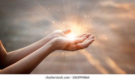 Woman hands praying for blessing from god on sunset background  - Shutterstock ID 1063994864
