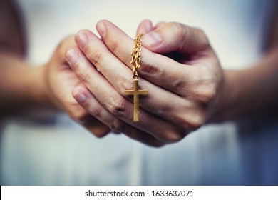 woman hands praying holding a beads rosary with Jesus Christ in the cross or Crucifix on black background. 
