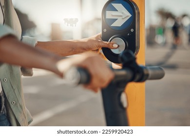 Woman, hands and pressing pedestrian crossing signal for safety, security or assurance for travel in the city. Hand of female at traffic light pushing button for crosswalk or street on electric bike