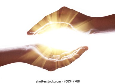 Mãos de mulher que protegem e contêm luz brilhante, brilhante, radiante e brilhante. Emitindo raios ou feixes de expansão do centro. Religião, conceito divino, celestial, celestial. Espaço de cópia de fundo branco