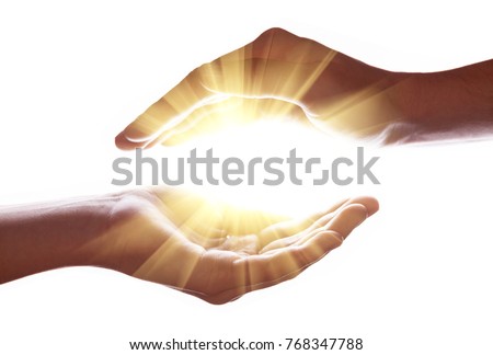 Woman hands protecting and containing bright, glowing, radiant, shining light. Emitting rays or beams expanding of center. Religion, divine, heavenly, celestial concept. White background copy space