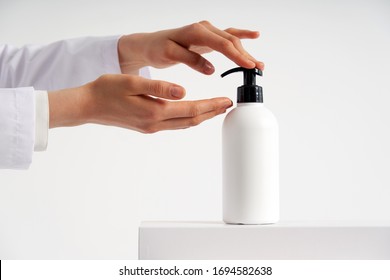 Woman hands pushing pump plastic soap bottle with copy space, using wash hand sanitizer gel pump dispenser. killing germs, bacteria and virus - Powered by Shutterstock