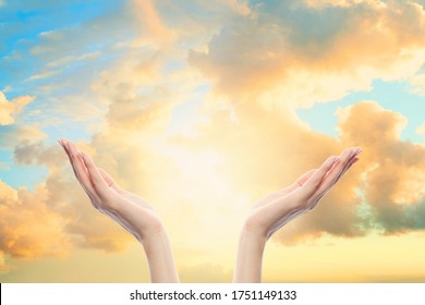 Frauenhände greifen im Gebet nach den Himmelswolken
