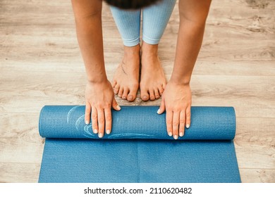 Woman Hands Rolled Up Yoga Mat On Gym Floor In Yoga Fitness Training Room. Home Workout Woman Close Up Hands Rolling Foam Yoga Gym Mat. Woman Barefoot Home Workout Sportive Healthy Lifestyle Concept