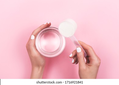 Woman Hands With A Scoop With Collagen Or Protein Powder And A Glass Of Water. Trendy Beauty Supplement For Healthy Skin And Bones. Flatlay, Top View.