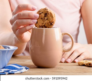 Woman hands with tea cup and cookie. Selective focus