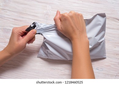 Woman Hands Tear Polythene Envelope