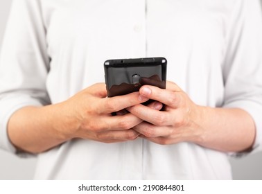 Woman Hands Texting Message At Phone. Female Using Android For Instant Messaging, Sharing Photos, Videos In Messengers Or Typing SMS. Frontal View. High Quality Photo