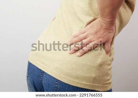 Woman hands touching her buttocks area suffering from pain. Health care and medical concept.