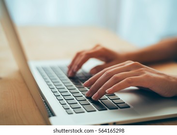 Woman hands typing on laptop keyboard at the office, Woman worker and business concept, Soft focus on vintage wooden table. - Shutterstock ID 564165298