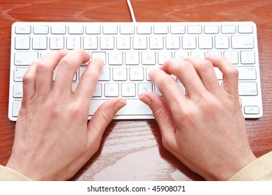 Woman Hands Typing On The White Keyboard