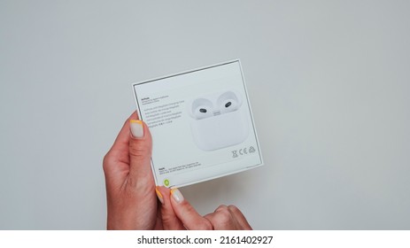 Woman Hands Unpacking New Model AirPods 3 2021 On White Background. The Box From Previous Release Of Apple Earphones Lying Down On Back Stage. Copy Space.