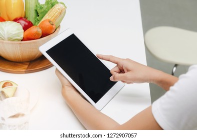 Woman Hands Using Mobile Tablet With Full Bowl Of Fresh Vegetables On Table In Kitchen At The Morning, Technology, Lifestyle, Healthy Food, Clean Eating, Dieting, Health Care And Weigh Loss Concept