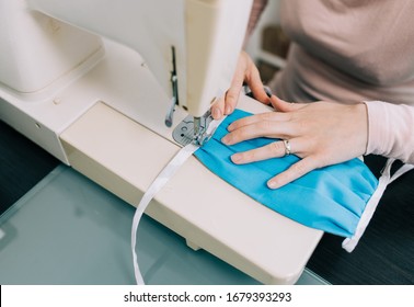 Woman hands using the sewing machine to sew the face medical mask during the coronavirus pandemia. Home made diy protective mask against virus. - Shutterstock ID 1679393293