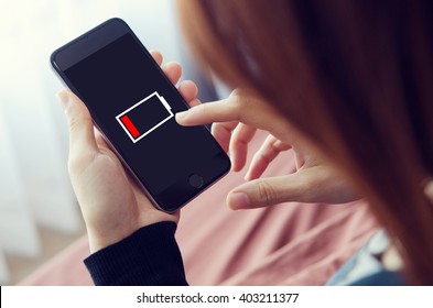 Woman Hands Using Smart Phone With Low Battery.