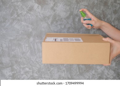woman hands using spray alcohol sanitizer cleaning parcel post, to prevent the virus and bacterias from postal sender, she protects herself and her family from viruses.woman giving package deliver - Shutterstock ID 1709499994