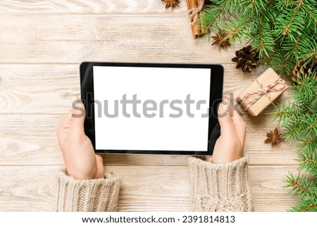 woman hands using tablet computer on wooden table bachground. cristmas shopping time. Happy Christmas mock up background, top view.