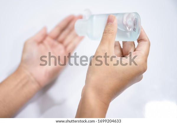 Woman hands washing by sanitizer
gel bottle, alcohol spray for prevention coronavirus disesse 2019
(COVID-19), bacteria and germ, health care concept (select
focus)