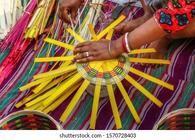 Woman hands weaving a basket with bamboo cane strands - Shutterstock ID 1570728403