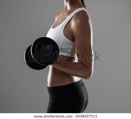 Woman, hands and weightlifting with dumbbell for muscle gain, workout or exercise on a gray studio background. Closeup of female person or bodybuilder with weight in arm or bicep curl on mockup space