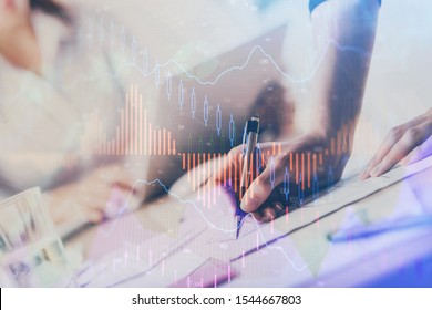 A woman hands writing information about stock market in notepad. Forex chart holograms in front. Concept of research. Multi exposure - Shutterstock ID 1544667803