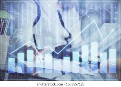A woman hands writing information about stock market in notepad. Forex chart holograms in front. Concept of research. - Shutterstock ID 1583557123