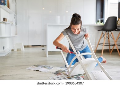 Woman As A Handyman At Home Painting A Chair Or Painting As Upcycling