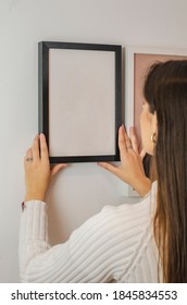 Woman Hanging Black Picture Frame With White Background