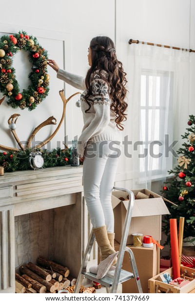 Woman Hanging Christmas Wreath Over Fireplace Stock Photo Edit