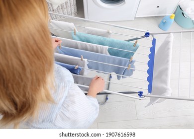 Frauen, die saubere Wäscherei auf einem Trocknungsgestell im Haus hängen, Nahaufnahme