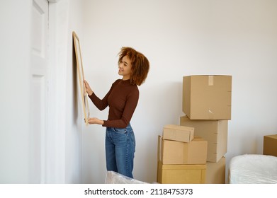 Woman Hanging Picture On The Wall