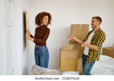 Woman Hanging Picture On The Wall