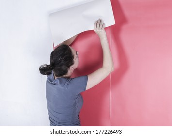 Woman Hanging Wallpaper. Decorating The Wall