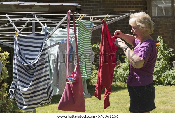 Woman\
hanging washing out to dry  on a clothes\
line
