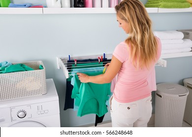 Woman Hanging Wet Clean Cloth To Dry On Clothes Line At Laundry Room