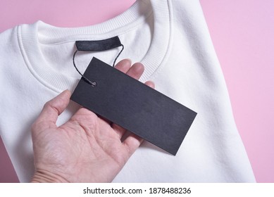 Woman Hans Holding Black Label Of Sweatshirt