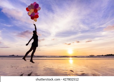 Woman in a happy dream flying in the sky lifted by helium balloons