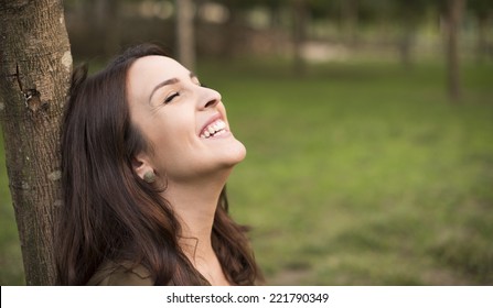 Woman With Happy Expression Relaxing On Meadow