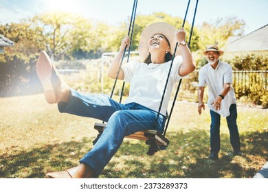 Woman, happy and fun on swing in retirement, playful and joy in summer vacation for quality time. Elderly people, support and love in relationship, funny and laugh for silly, goofy and holiday