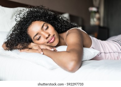 woman happy on bed smiling and stretching looking at camera