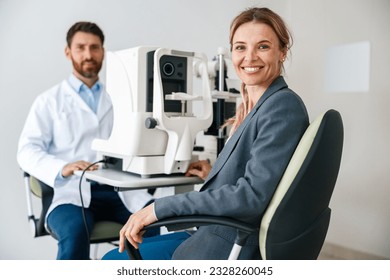 Woman happy with result after checking eyesight in ophthalmology clinic  - Powered by Shutterstock