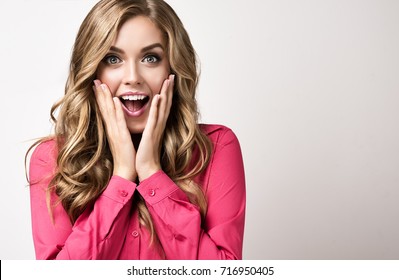 Woman  Happy And Surprised Shouts Holds Cheeks By Hand .Beautiful Girl  With Curly Hair  Pointing To Looking Right . Presenting Your Product. Expressive Facial Expressions Businesswoman  .