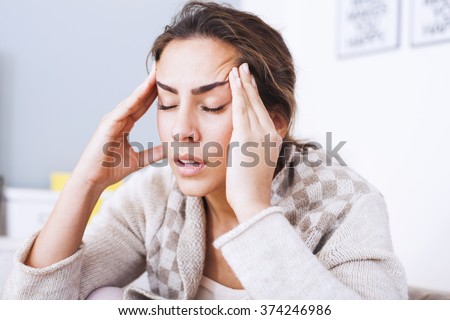 Woman with hard headache holding hands on head