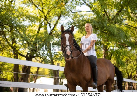 The woman has fun riding a horse on the farm