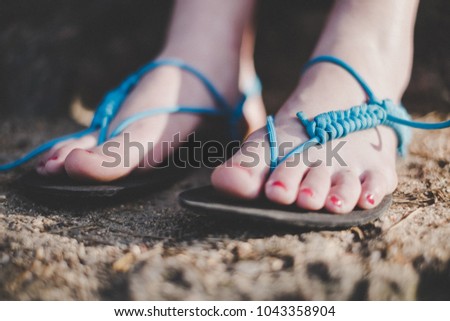 Woman has handmade sandals. Sandals made of rubber and strings. Detail of foot.