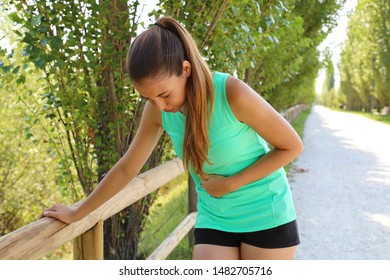 Woman Has Side Cramp. Young Woman Suffering From Abdominal Pain While Running Outdoor.