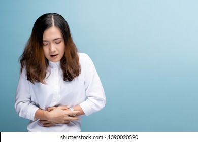 Woman has stomachache isolated over blue background