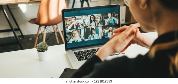 Woman has video conference with her remote team using laptop and camera