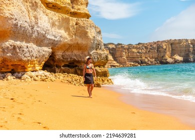 A Woman With A Hat In The Algarve On The Beach At Praia Da Coelha, Albufeira. Portugal